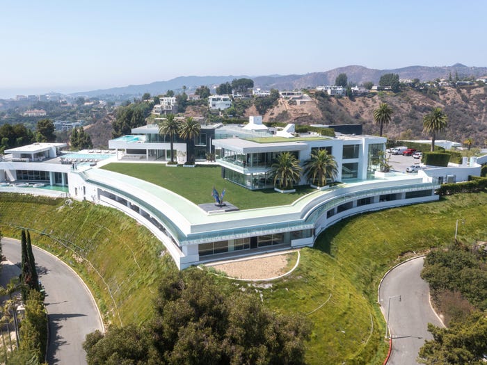 a sprawling white mansion, The One Bel Air, sits atop a short green hill