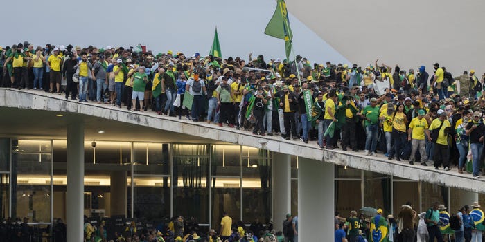 Supporters of Brazil's former President Jair Bolsonaro clash with security forces as they raid the National Congress in Brasilia, Brazil, on January 8, 2023. Some demonstrators climbed onto the roofs of the House of Representatives and Senate buildings.