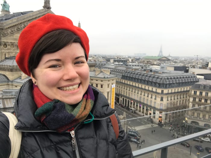 Moriah Costa posing for a selfie on a rooftop in paris on a cloudy day