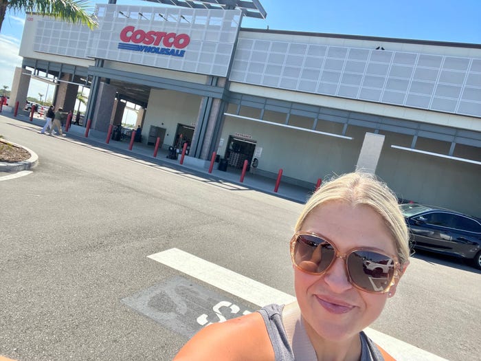 The writer poses in front of Costco