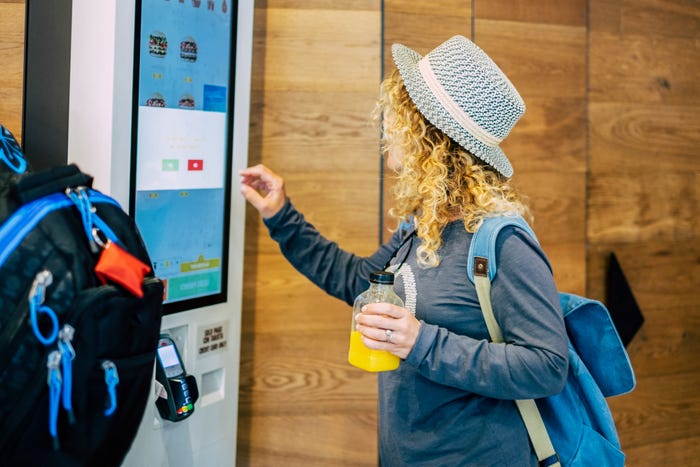 Woman ordering out a fast-food restaurant on a digital screen