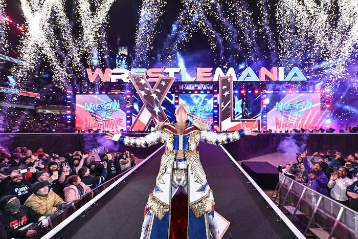 Cody Rhodes, wearing a white, gold, blue and red outfit, stands on the entranceway with his head thrown back, arms out and fireworks behind him during Night Two of WrestleMania 40 at Lincoln Financial Field on April 7, 2024 in Philadelphia, Pennsylvania.