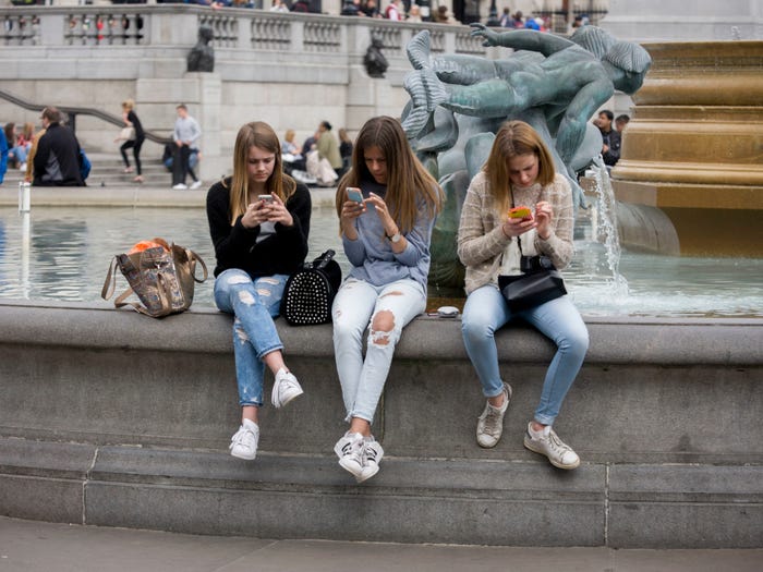 Three teenage girls on their phones.