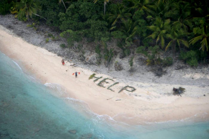 Two of three men stranded on the uninhabited island of Fanadik in Micronesia wave life jackets as a U.S. Navy P-8A Poseidon maritime patrol and reconnaissance aircraft discovers them