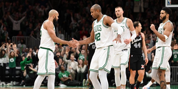Derrick White #9 high-fives Al Horford #42 of the Boston Celtics after making a three-point basket against the Detroit Pistons during overtime at TD Garden.