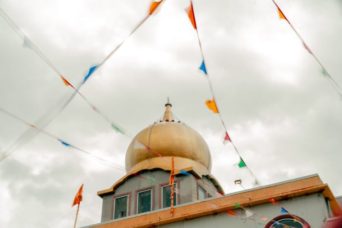 Gurdwara with colorful flags strung up.