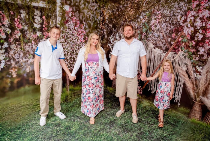 The Mearse family, standing in front of a floral background and smiling