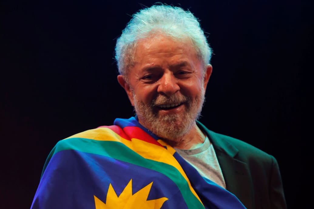 A flag is draped over a smiling Luiz Inacio Lula da Silva.