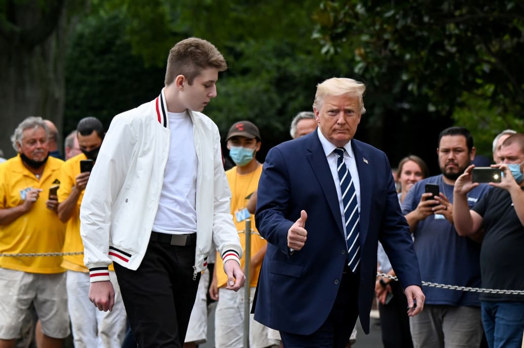 Barron Trump walks alongside Donald Trump to the White House.