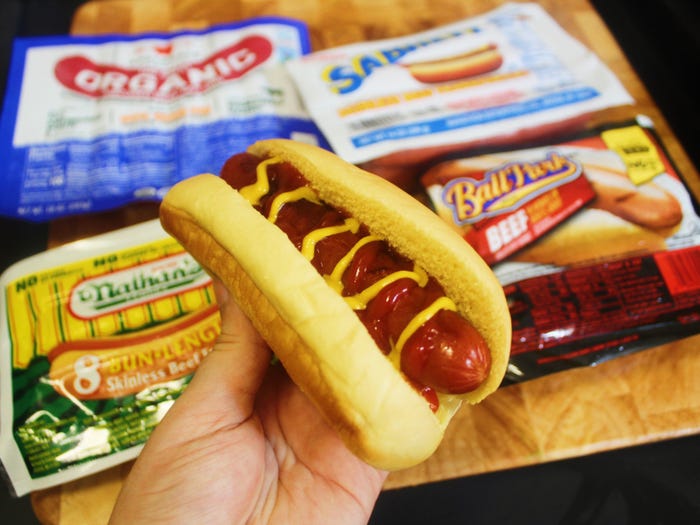 four packs of hot dog brands with hot dog with ketchup and mustard
