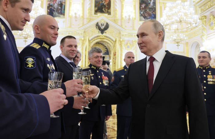 Russian President Vladimir Putin toasting Russian soldiers with a glass of champagne.