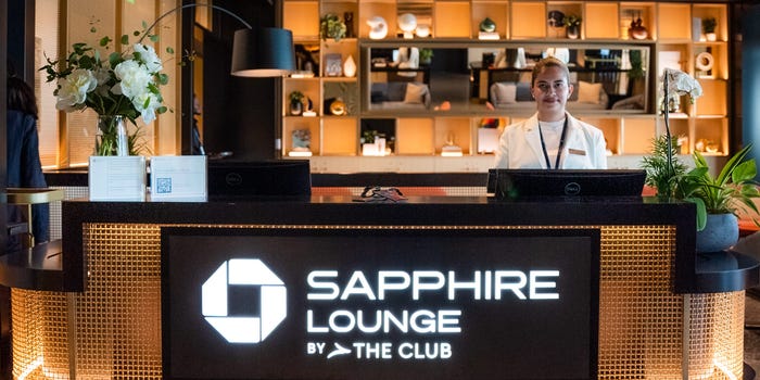 A female staffer stands behind the reception desk at the Boston Chase Sapphire Lounge.