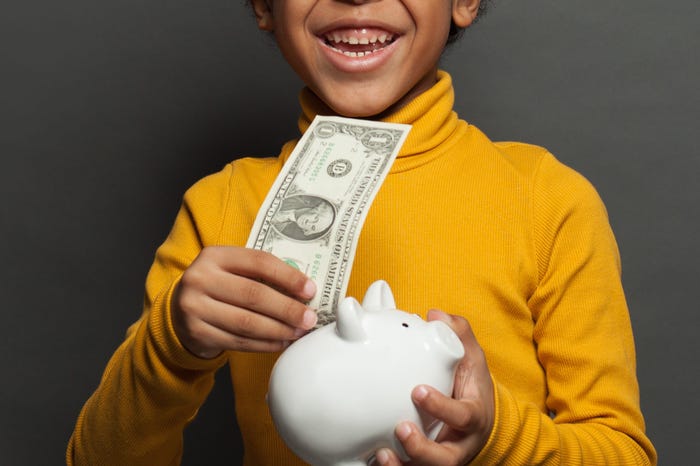 Laughing child with money box and one us dollar on blackboard background - stock photo