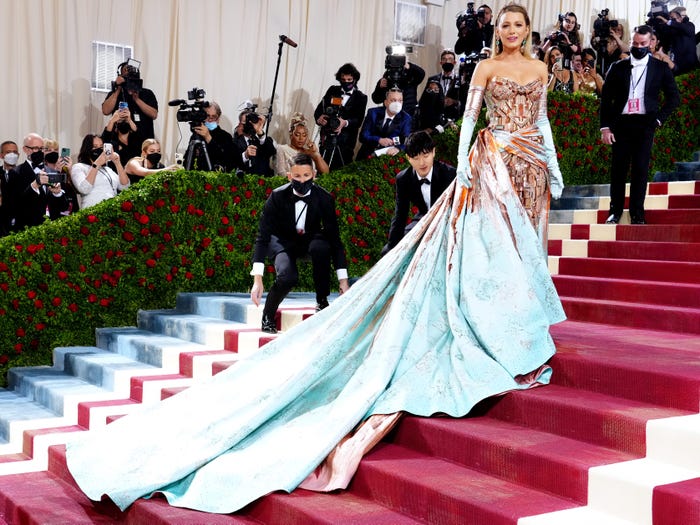 Blake Lively on the Met Gala stairs in 2022 in her copper and teal gown meant to represent the Statue of Liberty.