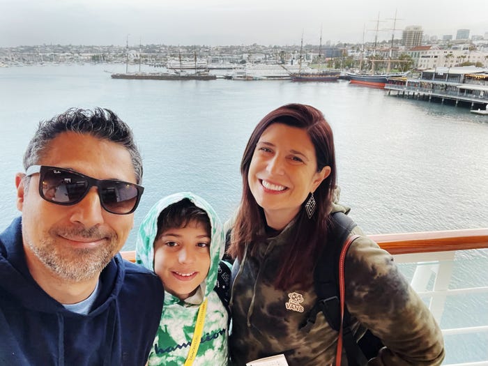 Author Amanda Adler with her husband and son on a cruise ship in front of water