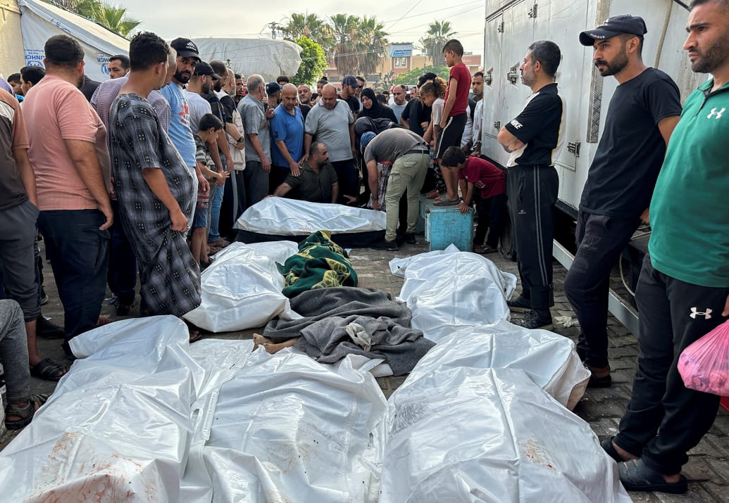 Mourners gather next to the bodies of Palestinians killed in Israeli strikes.