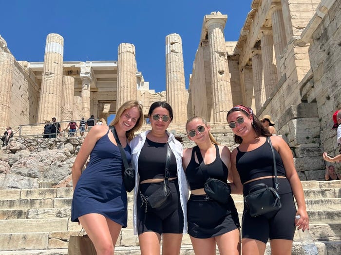 jordana and her friends posing in front of the acropolis in greece