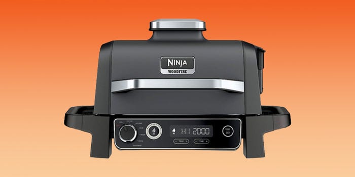 The Ninja Woodfire Outdoor Grill against a gradient orange background.
