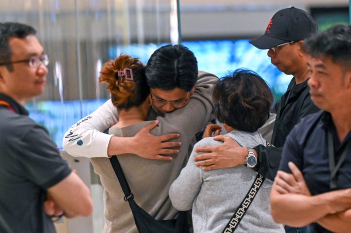 Passengers of Singapore Airlines flight SQ321 from London to Singapore, which made an emergency landing in Bangkok, greet family members upon arrival at Changi Airport in Singapore on May 22, 2024.