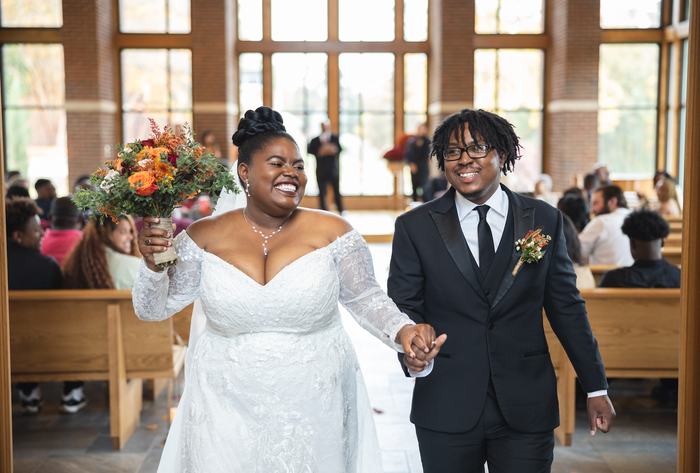 Terryn Witherspoon-Woolfolk as a bride holding hands with her groom as they walk down the aisle
