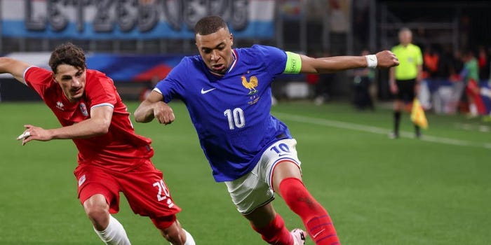 Kylian Mbappe of France controls the ball against Eldin Dzogovic of Luxembourg.