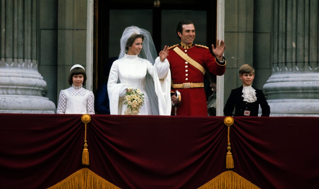 Princess Anne, Princess Royal and Mark Phillips wave from the balcony of Buckingham Palace following their wedding with Prince Edward, Earl of Wessex (R) on November 14, 1973 in London, England.
