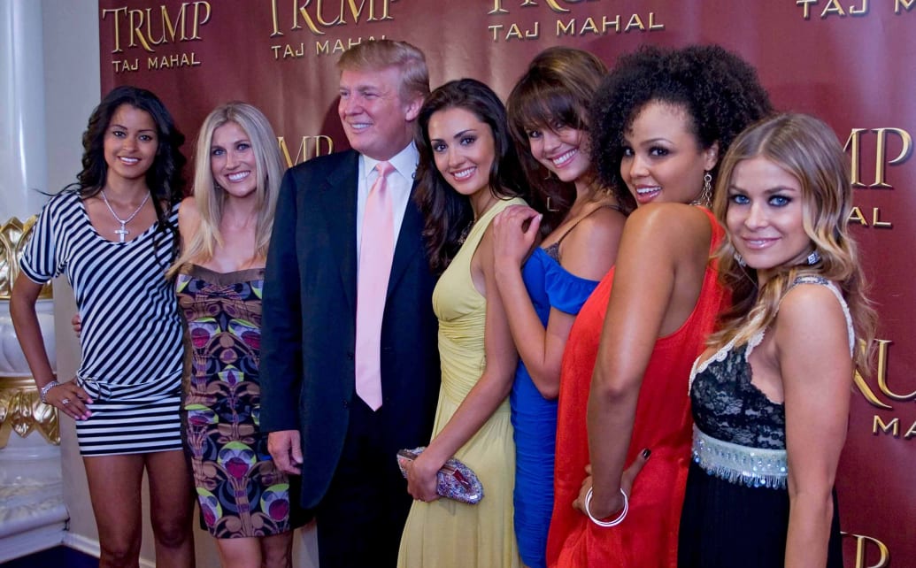 Carmen Electra, right, poses with the Deal or No Deal Girls in 2007. Trump’s there, too, celebrating his 61st birthday.